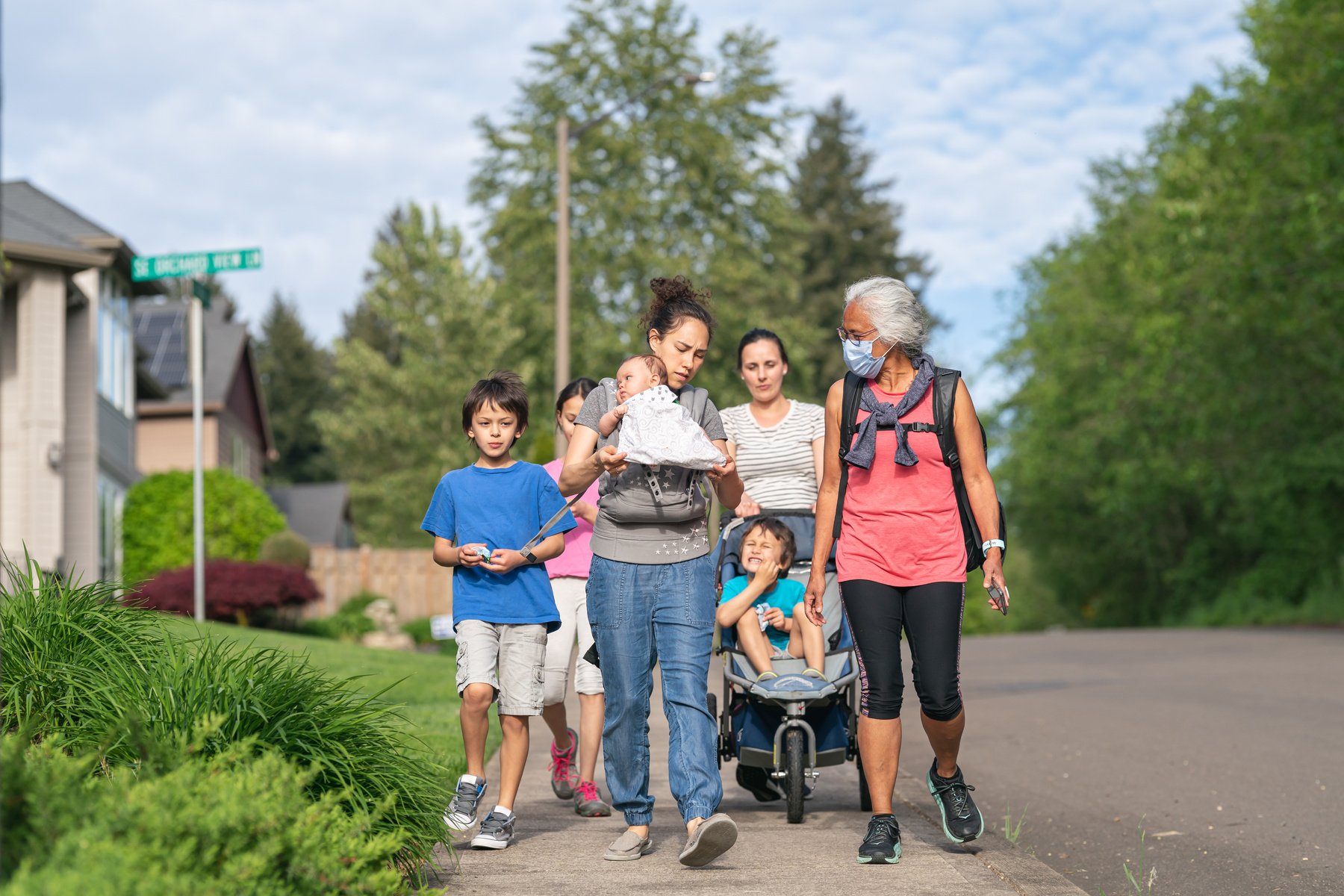 Multigenerational group of family walking through a neighborhood